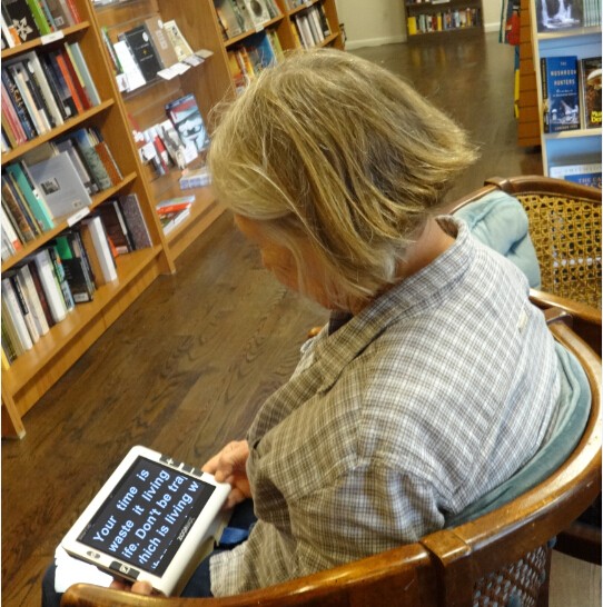 People With Vision Impaired Is Using Handheld Video Magnifier Snow 7 Hd For Reading