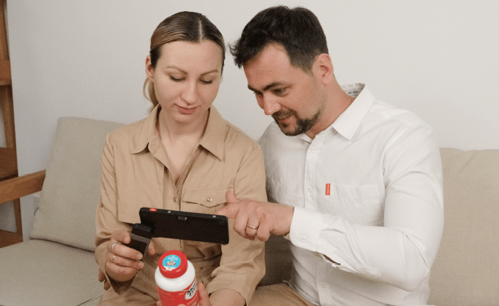 couple using luna 6 video magnifier to look at pill bottle